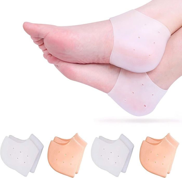 Feet adorned with gel heel protectors featuring ventilation holes, displayed alongside two pairs of protectors in different colors