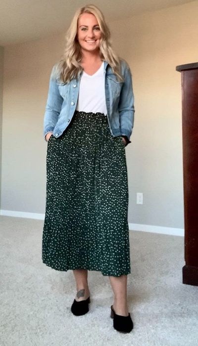 A reviewer wearing a high-waisted pleated midi skirt in green