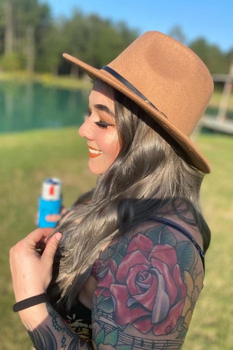 reviewer wearing a tan hat featuring a slim buckled band