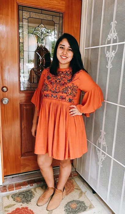 Reviewer wearing the orange version of the dress.