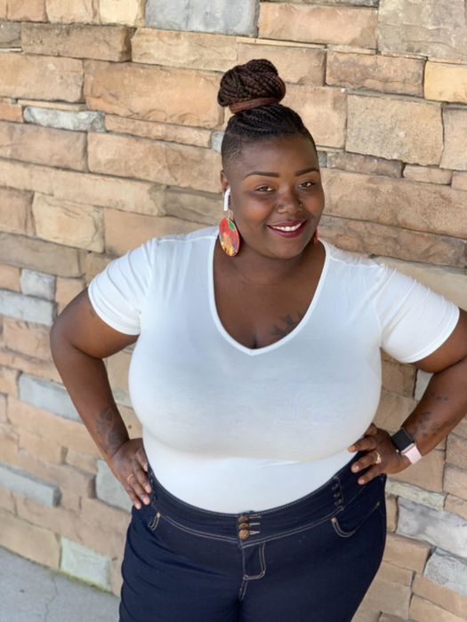 A reviewer wearing the white bodysuit