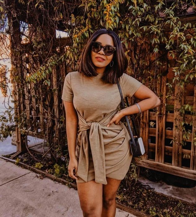 A reviewer modeling the taupe-colored dress