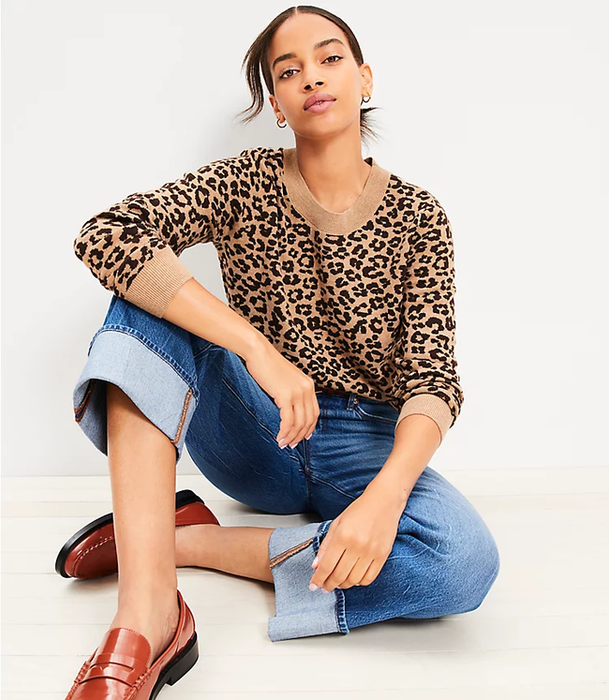 model wearing a tan and black pullover styled with jeans and loafers