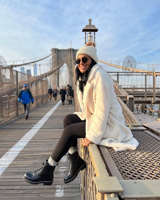 a reviewer showcasing the black boots with white stitching