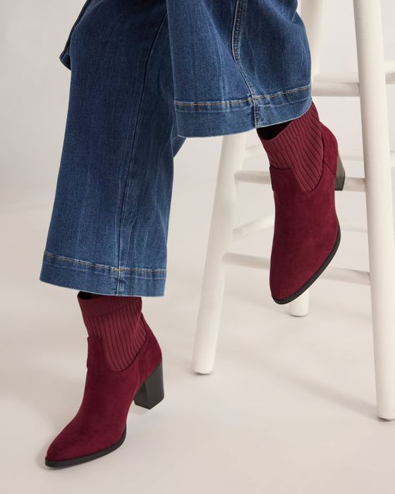 A model showcasing the boots in a deep red shade