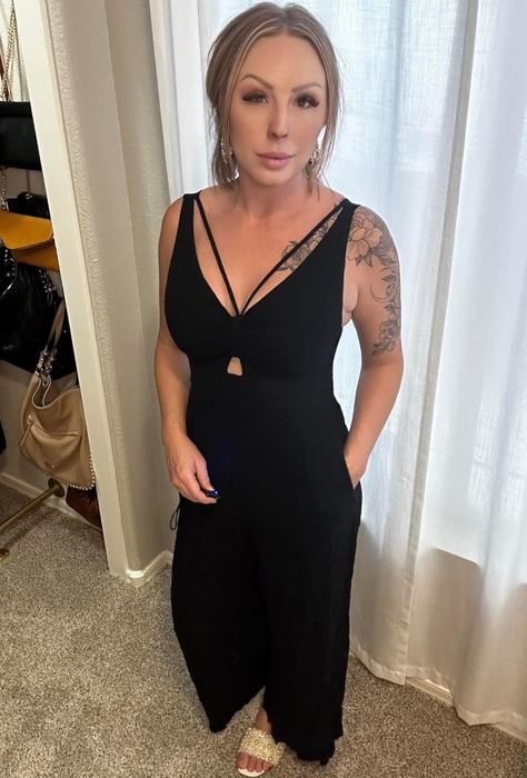 A reviewer showcasing the black jumpsuit