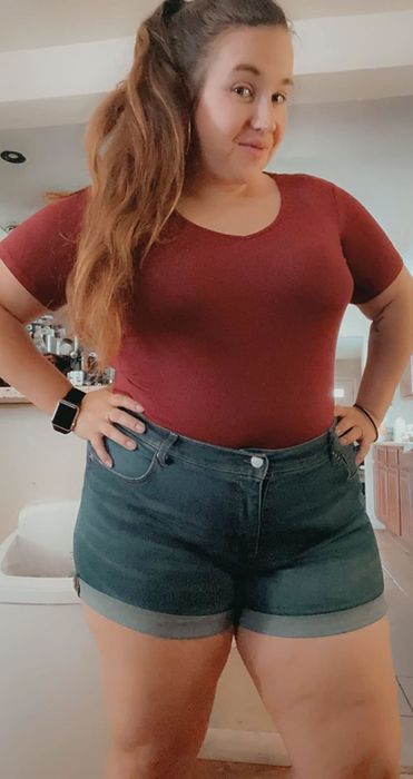 A reviewer showcasing the dark red bodysuit