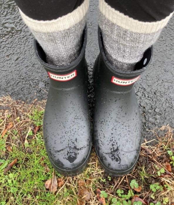 A reviewer steps out in the black boots, even in the rain.