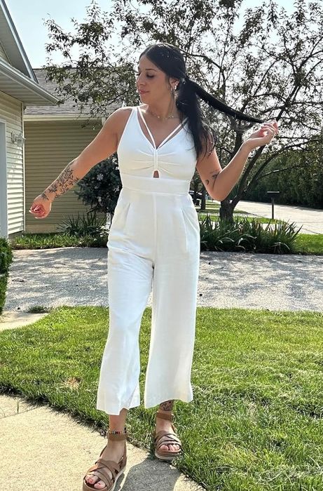 A reviewer modeling the white jumpsuit