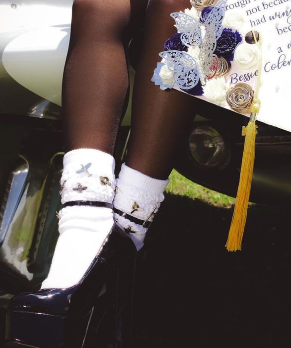 A reviewer wearing the white socks paired with chunky black heels