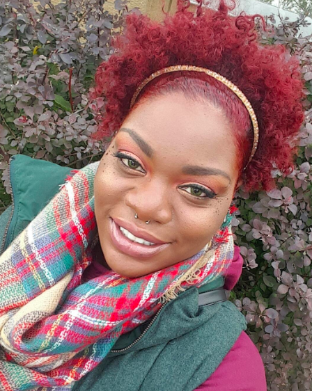A reviewer showcasing the scarf in green, red, and tan plaid