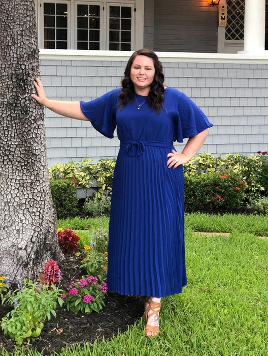 reviewer wearing the blue version of the dress