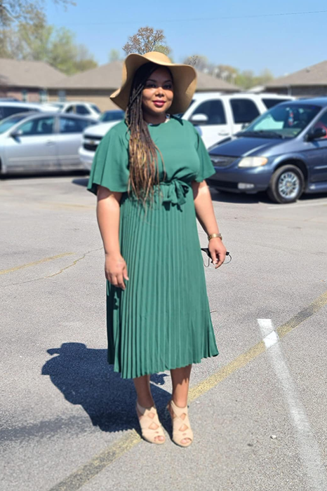 reviewer showcasing the dress in green