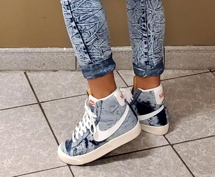 A reviewer wearing the blue and white sneakers