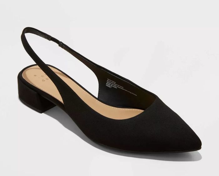 A single black slingback shoe with a pointed toe and a low block heel