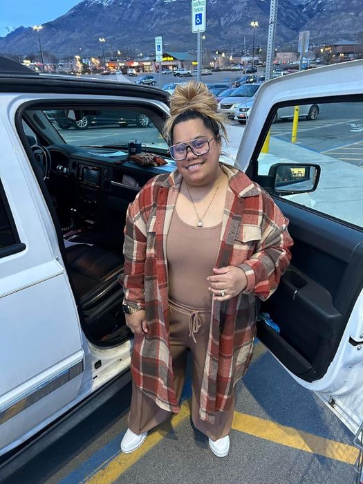 A reviewer showcasing the orange plaid coat