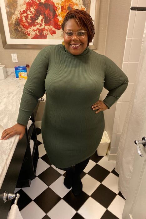 A reviewer showcasing the olive long-sleeve sweater dress