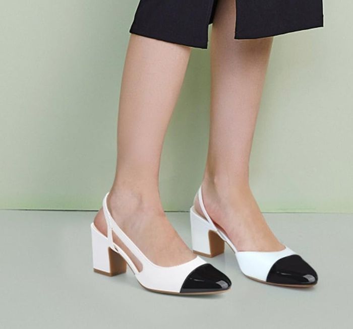 A person wearing a knee-length slit dress, showcasing stylish two-tone block heel shoes