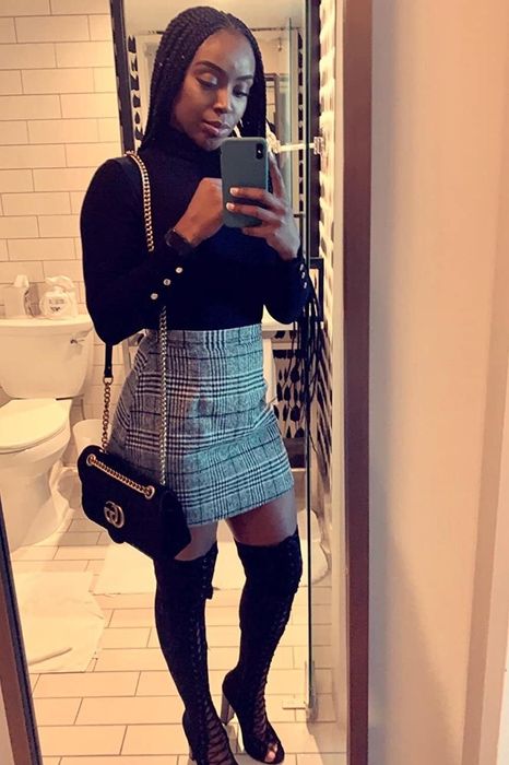 A reviewer styling the black and white fitted skirt with over-the-knee boots