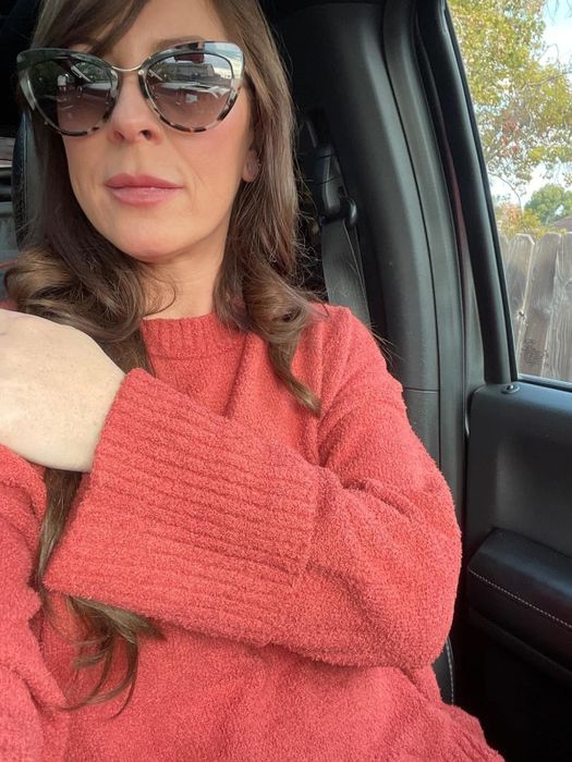 A reviewer showcasing the rust sweater