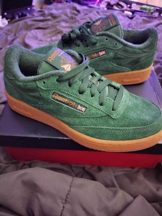 A close-up shot of green Reebok sneakers with gum soles placed on a shoebox