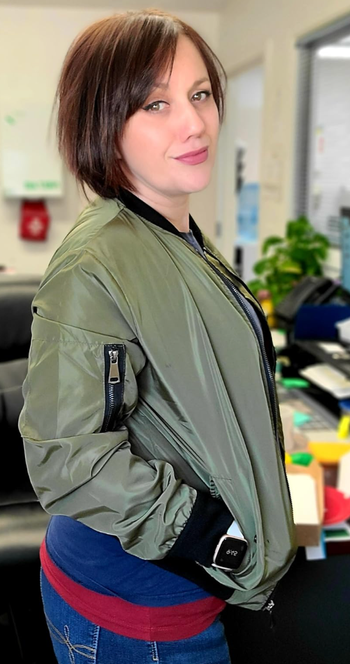 A reviewer showcasing the green version of the jacket.