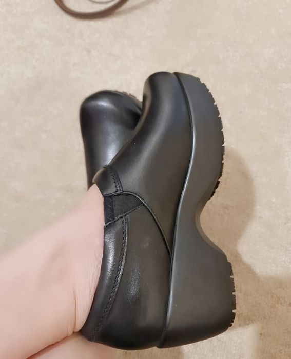 A reviewer wearing black clogs