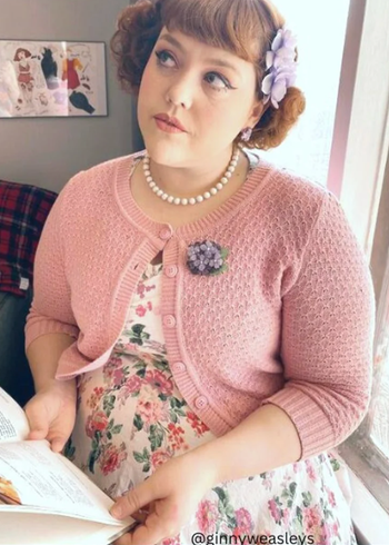 A model wearing a pink cropped cardigan.