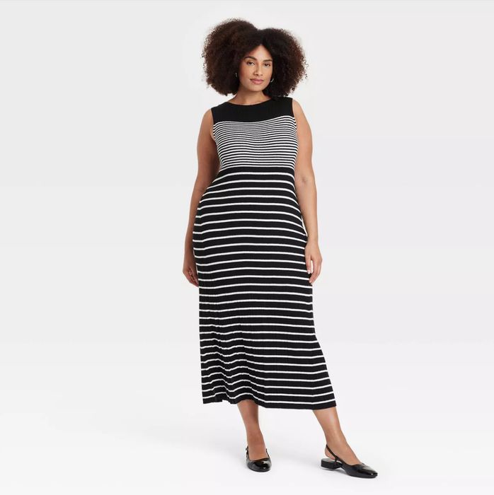 A person modeling a sleeveless black and white striped midi faux plisse dress