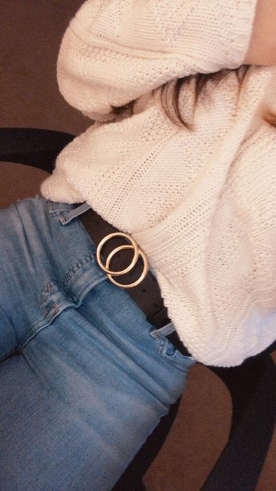 reviewer styling the faux leather belt with jeans and a sweater