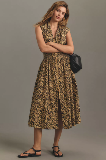 A model in a sleeveless leopard-print midi dress featuring a cinched waist.