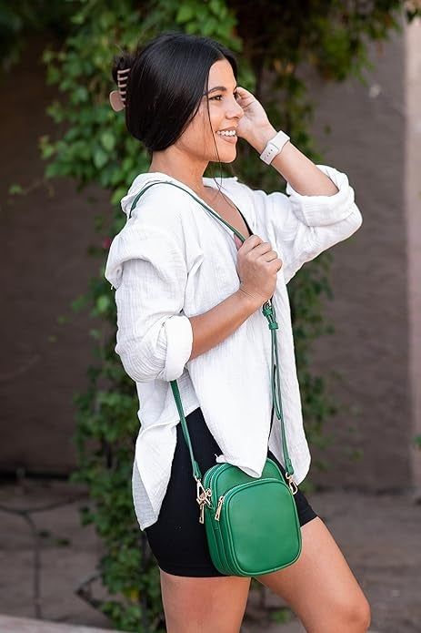 model smiling while wearing the green crossbody bag