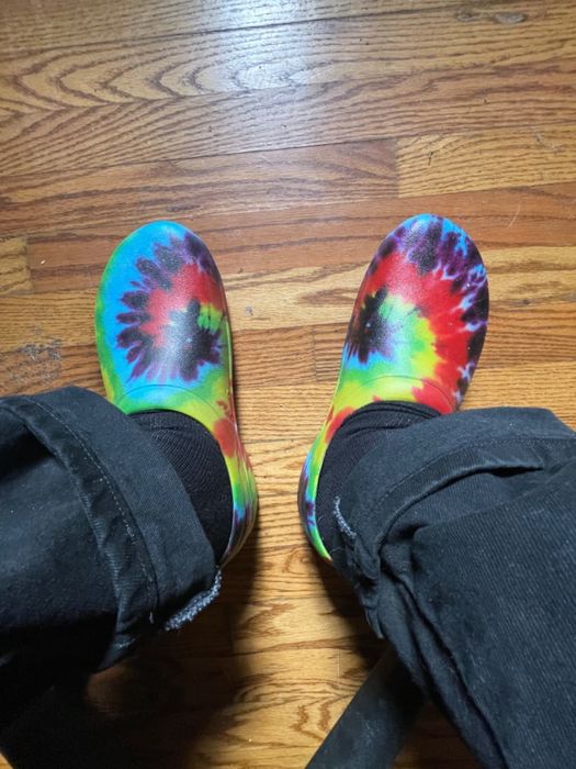 A reviewer showcasing the tie-dye clogs