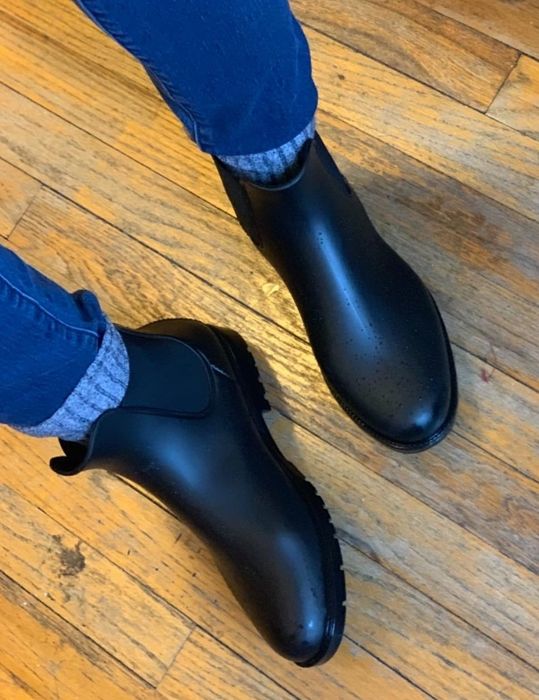 A photo of a reviewer styling the boots with thick gray socks and jeans