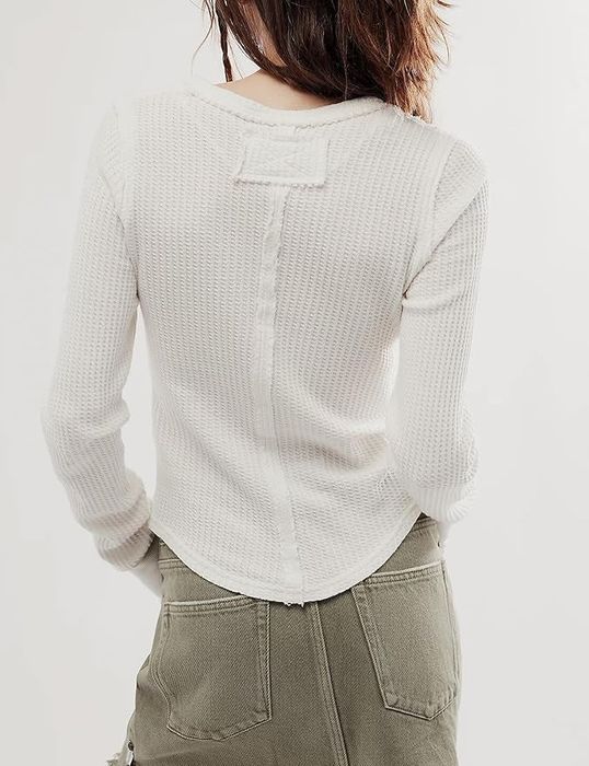 A back view of a person wearing a waffle-knit long-sleeve top and cargo-style utility pants, featured in a shopping article.