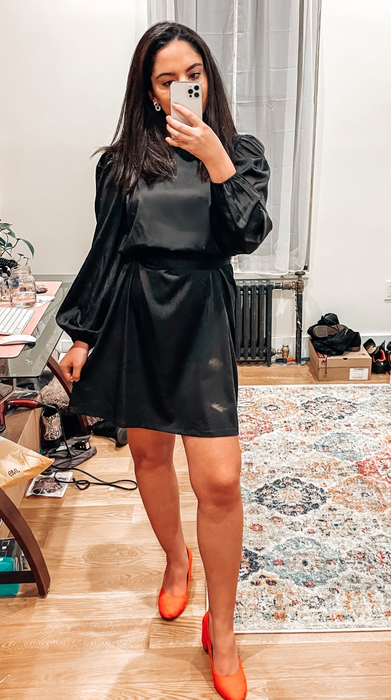 reviewer wearing the black silk dress