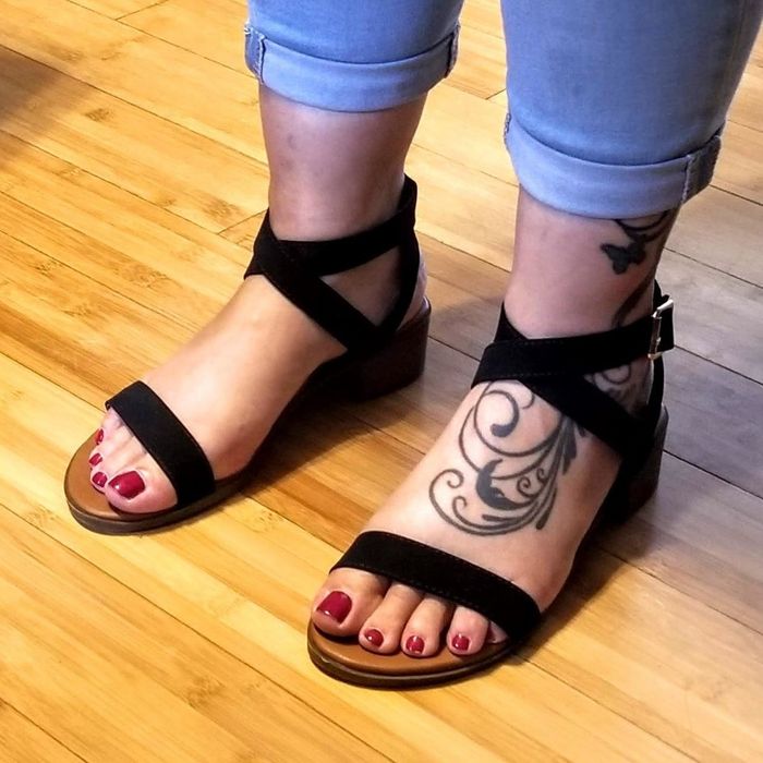 a photo of a reviewer in jeans, paired with black strappy block heel sandals