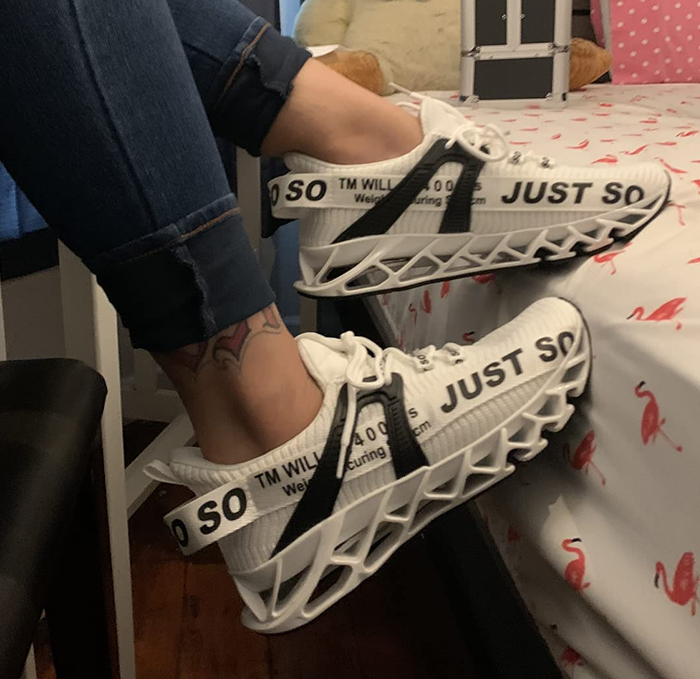 A reviewer sporting white and black sneakers.