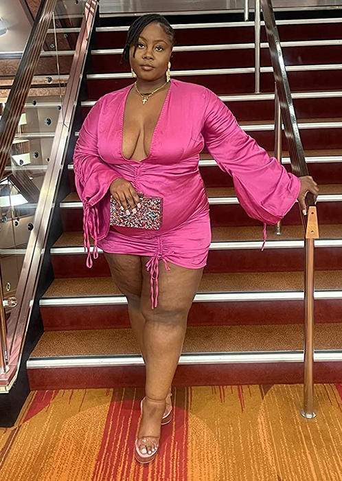 another reviewer in a pink dress holding the multicolored clutch