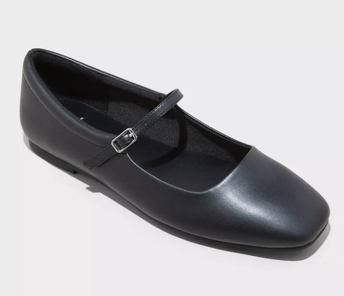 A black Mary Jane-style shoe with a single strap running across the top of the foot
