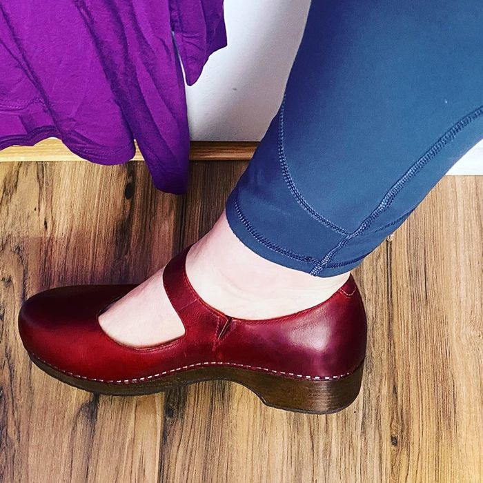 A profile shot of a reviewer wearing the clogs in burgundy