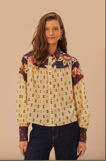 A model wearing a floral-patterned blouse.