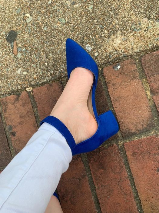 A reviewer styles the same pump design in dark blue with slim gray trousers