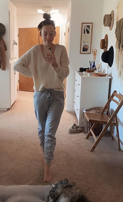 The same reviewer wearing the grey version of the pants.