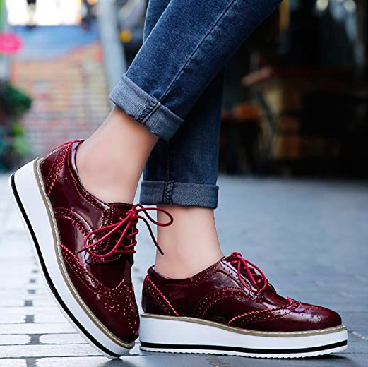 A model sporting red platform oxford shoes paired with cuffed jeans