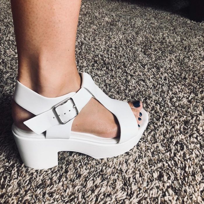 a reviewer's white sandal with a thick heel and a bold buckle