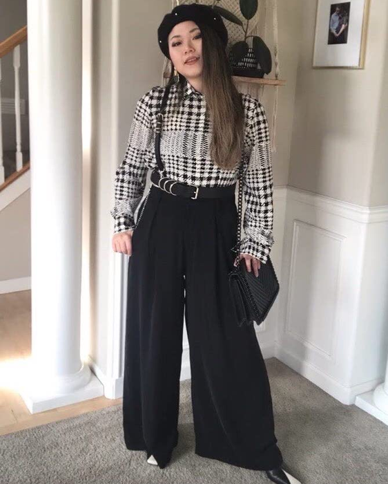 reviewer styling the black pants with a black and white top