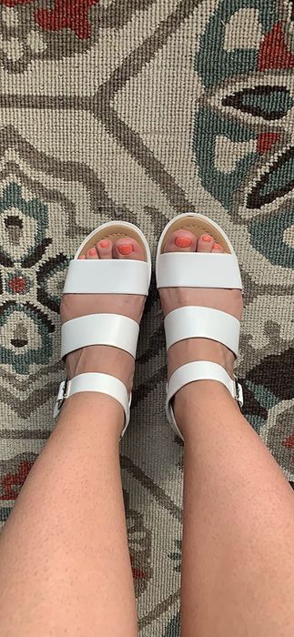 A reviewer wearing the white sandals