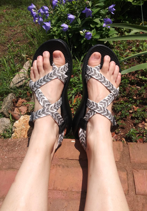 a reviewer wearing grey and white patterned Chacos