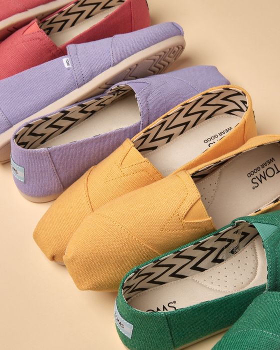 A variety of TOMS shoes in solid colors showcased for easy shopping selection